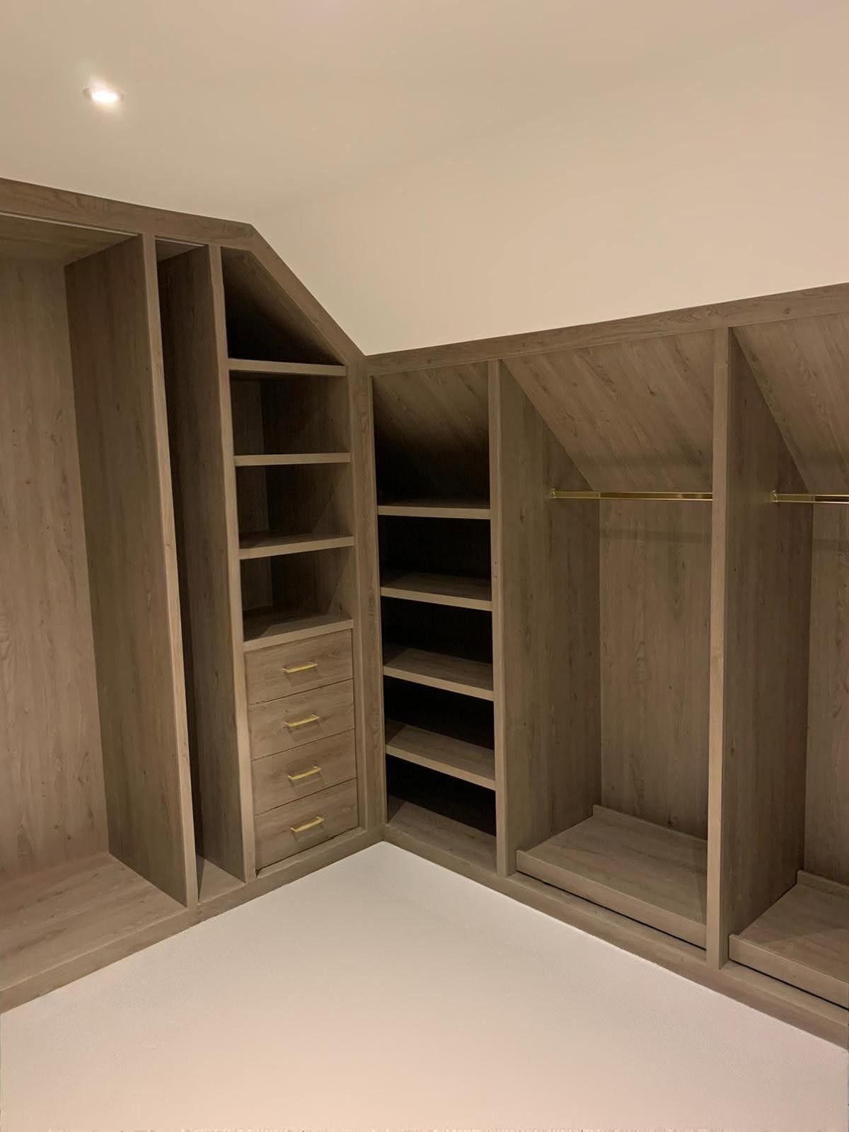 Corner view of fitted loft storage with drawers and open shelving in a loft conversion