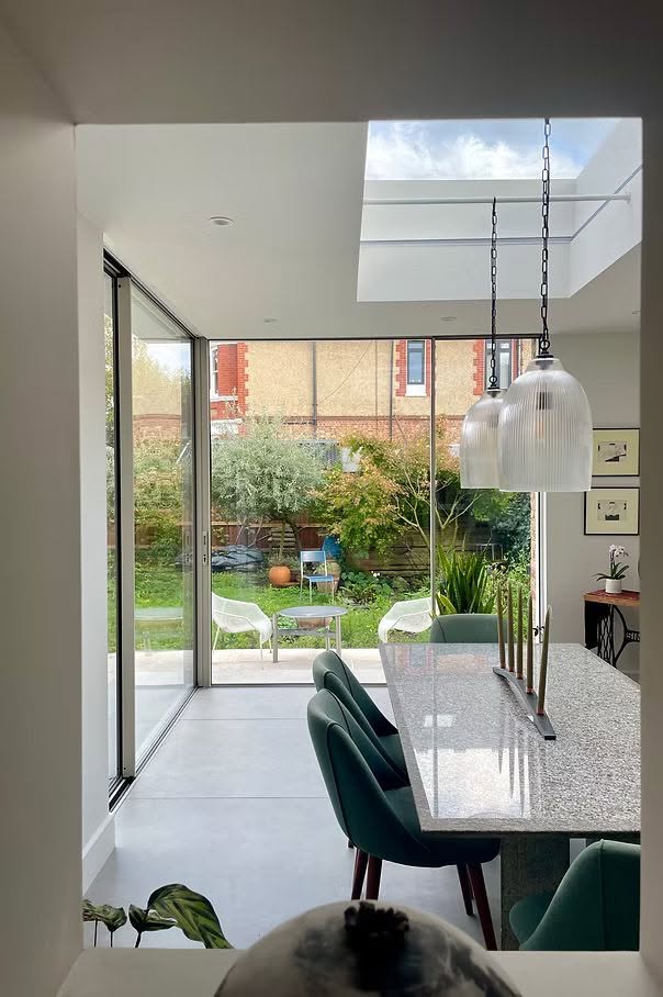 Extension dining area seen through an internal window with a rooflight above