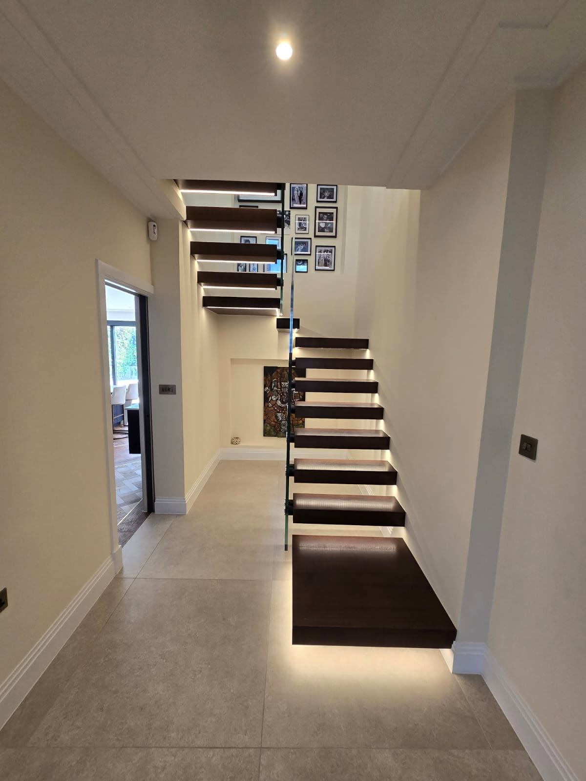 LED-lit floating timber stair treads set against a neutral plastered wall