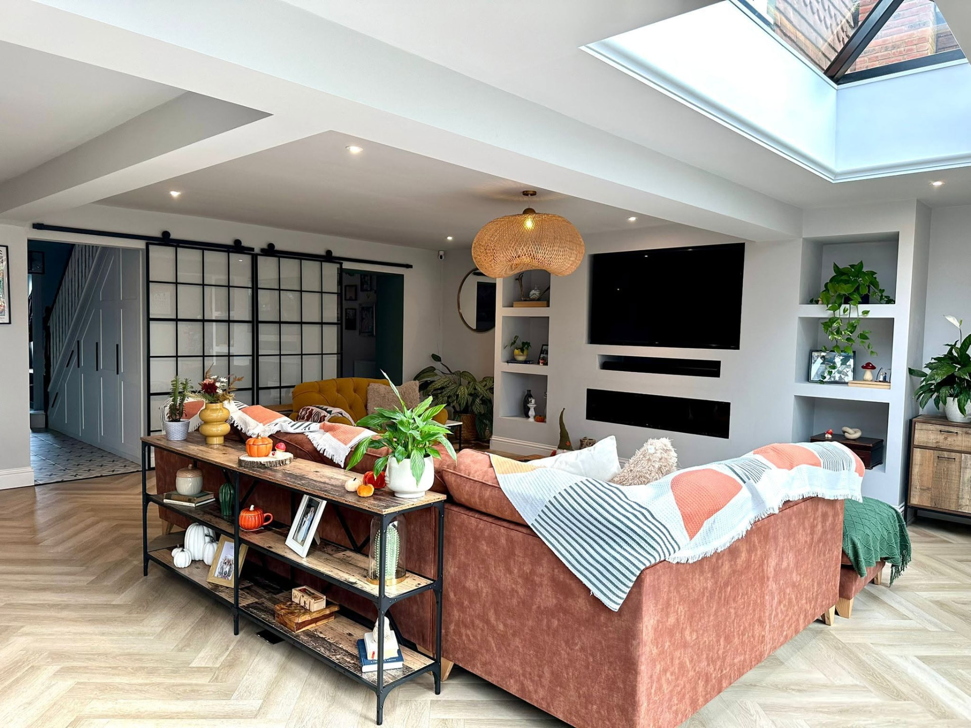 Open-plan living room extension with herringbone flooring, rooflights and bespoke shelving